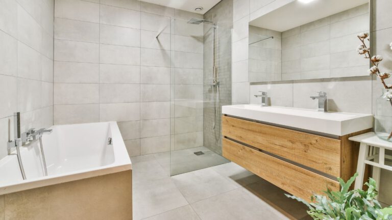 Ein stilvolles helles Badezimmer mit Holzelementen.